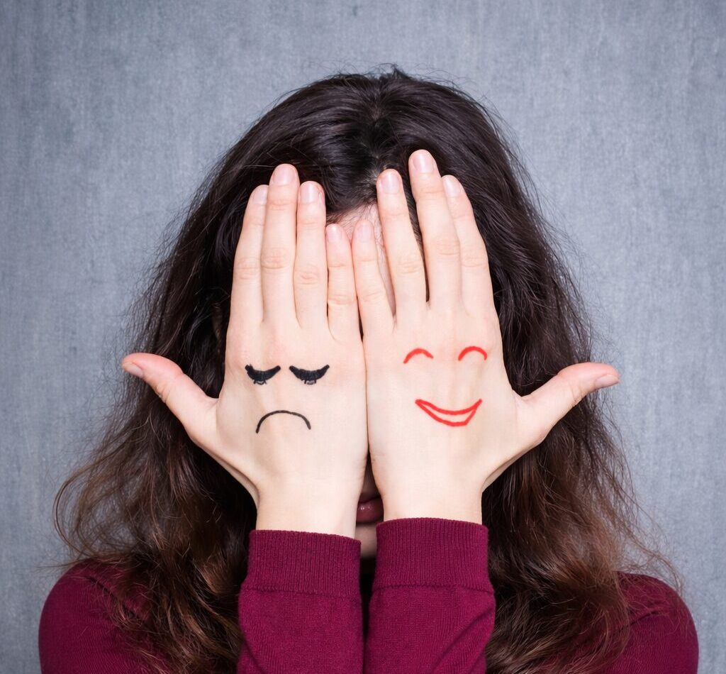 Woman pictured closely with her hands on her face