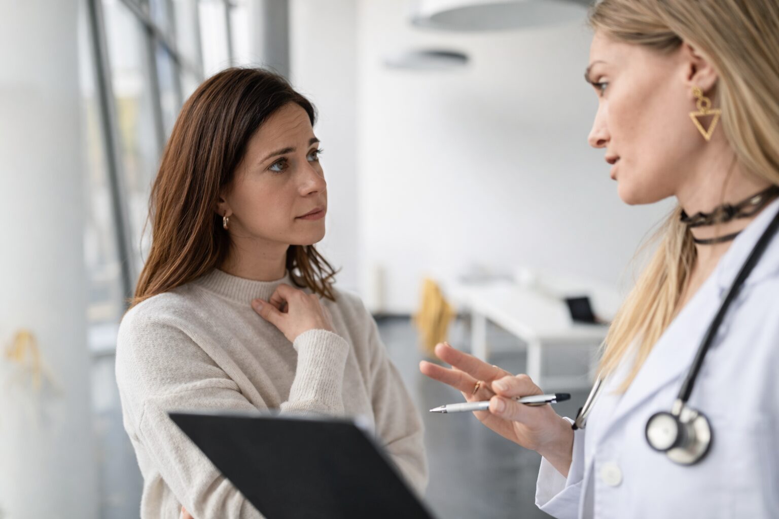 Medical sister talking to another woman looking worried